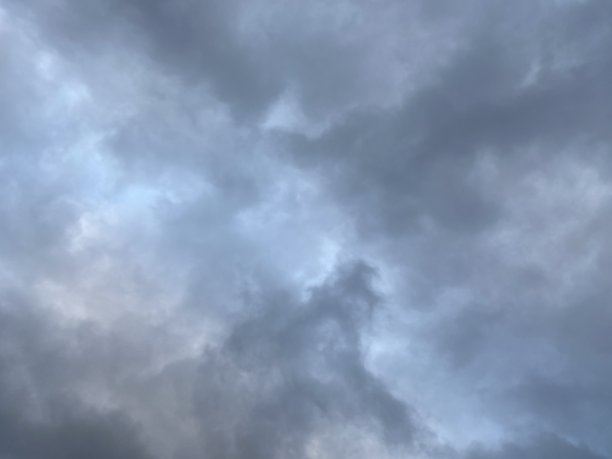 蓝色天空背景中的深灰色云图片下载