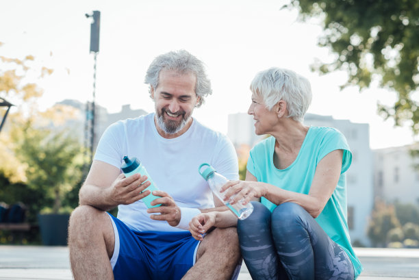 一对成年夫妇在城市里跑步后休息的照片图片下载
