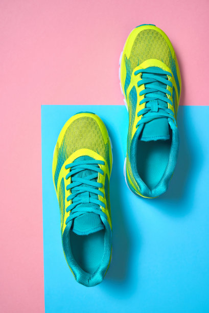 一双彩色背景的运动鞋。新运动鞋粉红色和蓝色粉彩背景，复制空间。穿跑鞋的头顶投篮。俯视图，平躺图片下载