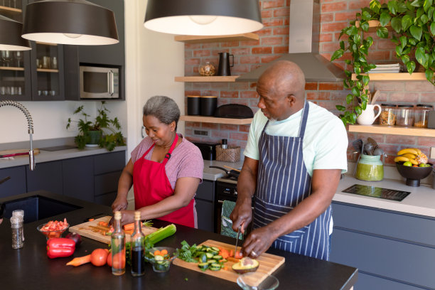 快乐的非裔美国老夫妇一起在厨房做饭图片下载