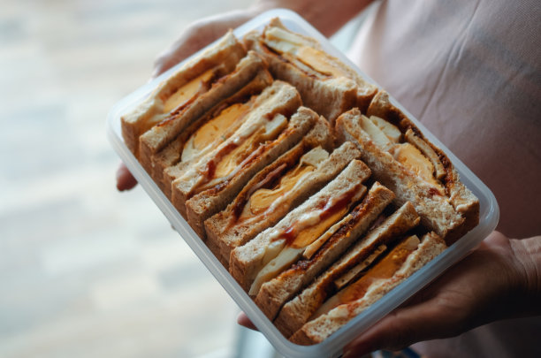 裁剪视图女人拿着一盒三明治周末野餐图片下载