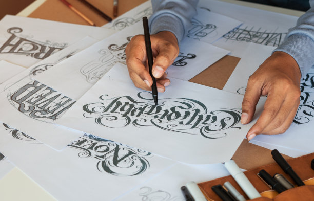 字体印刷书法艺术家设计师画草图写让拼写钢笔毛笔墨水纸桌子艺术品。工作场所的设计工作室。图片下载