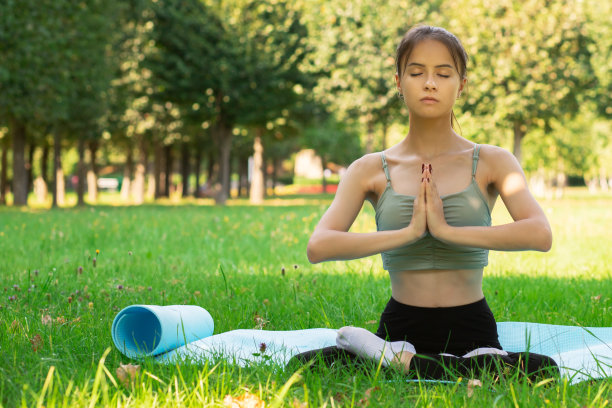 在城市公园里做瑜伽，户外运动和健身，年轻女子冥想，在大自然上做操图片下载