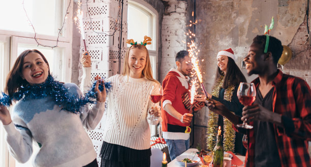 一群朋友在聚会上放烟花。年轻的朋友们喝酒庆祝除夕。图片下载