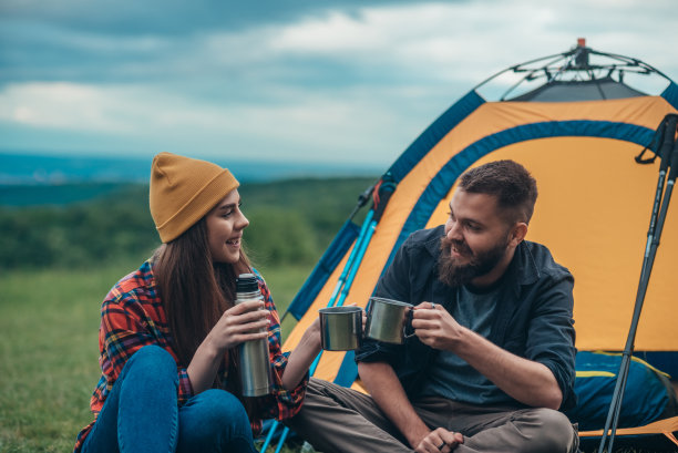 几个露营者用金属杯和保温瓶喝咖啡图片下载