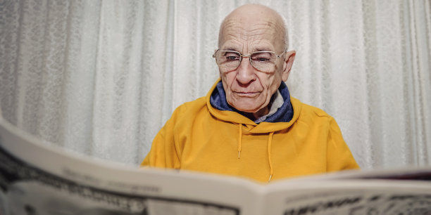 戴眼镜的老人看报的照片图片下载