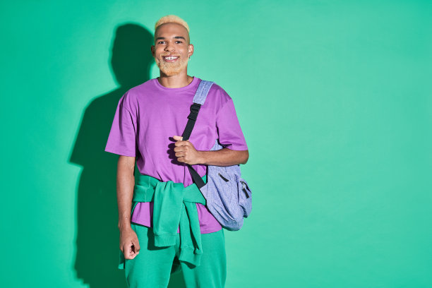 多种族男性紫色t恤拿着他的背包和滑稽的表情图片下载