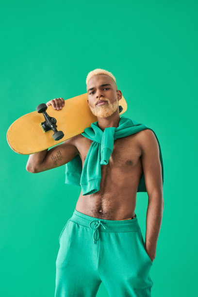 多种族滑板手在他的肩膀上，同时在绿色的孤立姿势图片下载