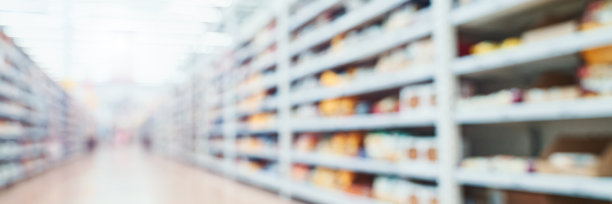 食品市场内部。走廊背景变得模糊。商店货架上。库存商品。图片下载