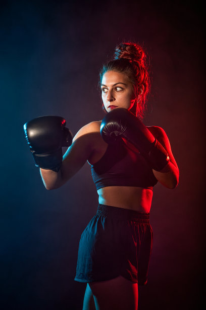运动女子做拳击练习，直接命中。年轻女孩的照片。力量和动力。图片下载