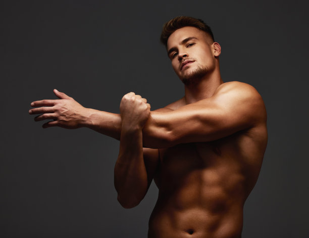 一个英俊的和运动的年轻男子的裁剪肖像在工作室对黑暗的背景下赤裸上身图片下载