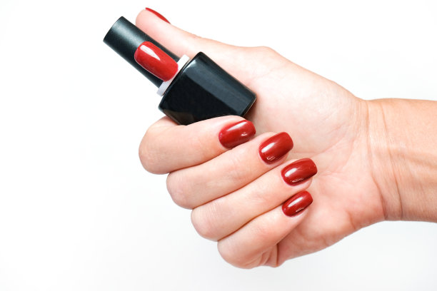 修指甲。一个女人手里拿着一瓶指甲油。虫胶。图片下载