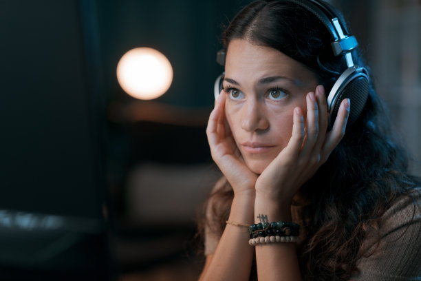 一个戴着耳机看视频的年轻女人图片下载