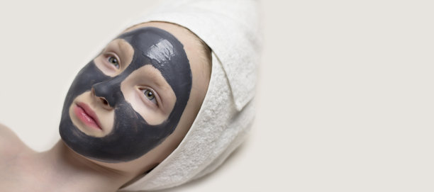 清洁面膜敷在脸上。戴着炭炭面具的女孩。图片下载