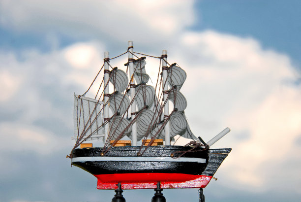 在多云的天空前有一个小帆船模型图片下载