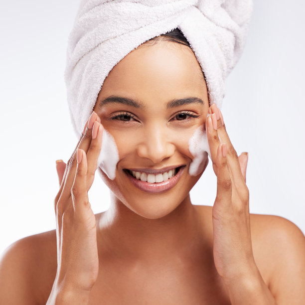 一个美丽的年轻女子在白色背景下洗脸的画室肖像图片下载