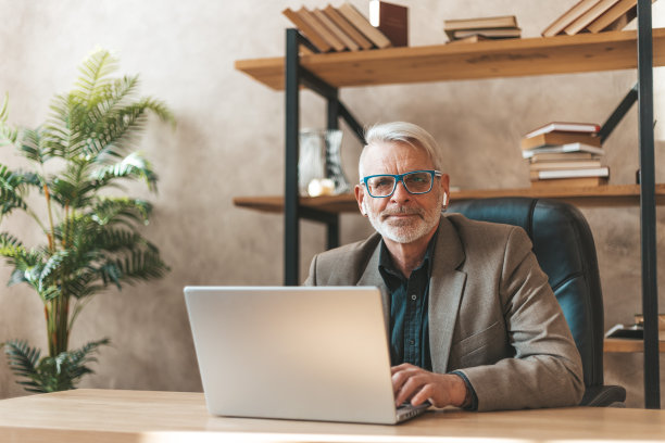 这个人忙于工作。一位老教授正在写一篇科学文章。律师为公司检查合同图片下载