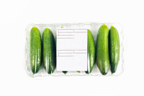 新鲜收获的小黄瓜包装和标签上的白色背景图片下载