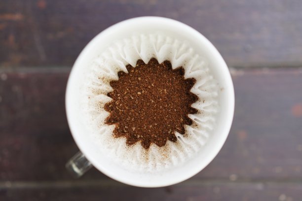 俯视图滴咖啡过滤器，木材背景图片下载