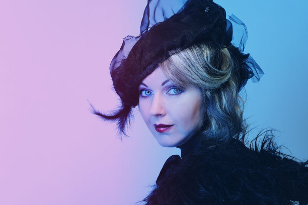 优雅的中年妇女戴着黑色的帽子，戴着面纱，穿着奢华的裙子图片下载