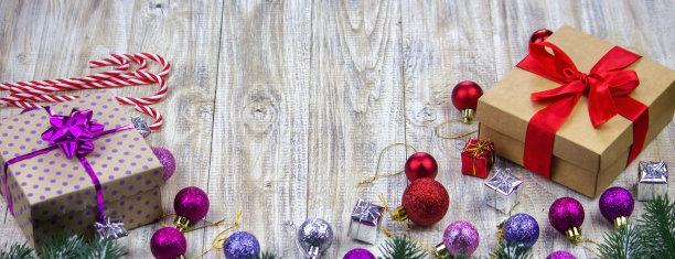 木制背景上装着新年玩具的圣诞盒子。图片下载