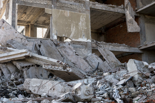 前景中有一堆瓦砾的废弃混凝土建筑。背景图片下载