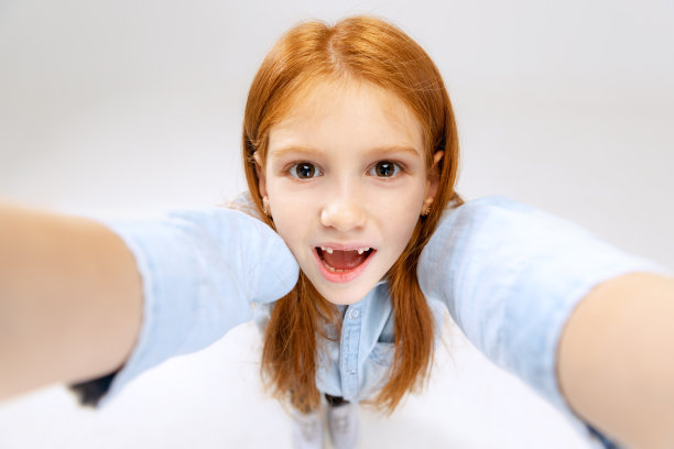 小白人女孩的肖像，孩子的姿势，自拍孤立在白色的工作室背景。图片下载