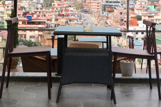 在晴朗的下午，餐厅阳台座位俯瞰城市景观，天际线和山景，加德满都，尼泊尔图片下载