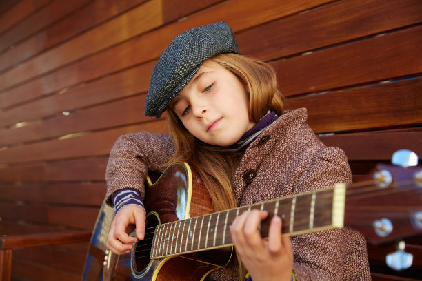 金发小妞戴着冬天的贝雷帽弹吉他图片下载