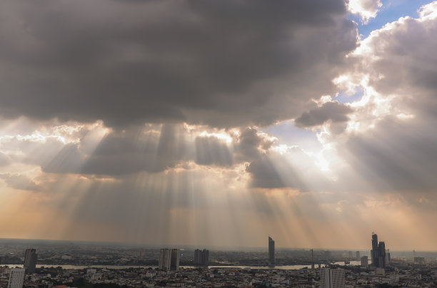 阳光穿过云层，照耀在曼谷的天空上。图片下载