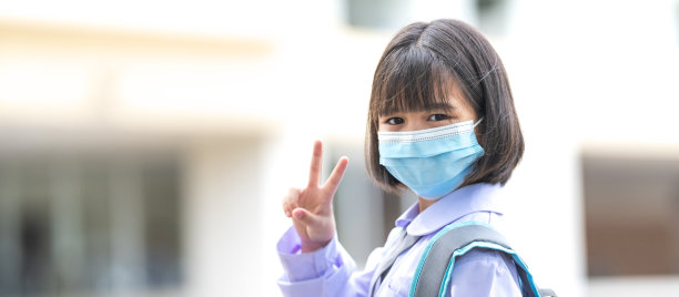 新冠肺炎疫情后，身穿校服、戴着医用口罩的亚洲小朋友们兴高采烈地回到学校。回到学校概念库存照片图片下载