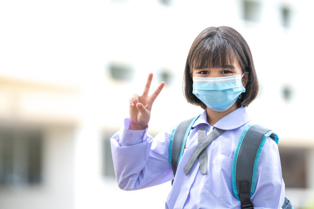 新冠肺炎疫情后，身穿校服、戴着医用口罩的亚洲小朋友们兴高采烈地回到学校。回到学校概念库存照片图片下载