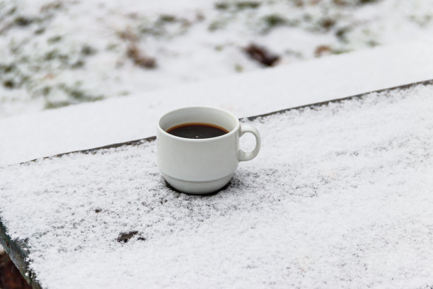在冬天，在被雪覆盖的桌子上喝一杯咖啡图片下载