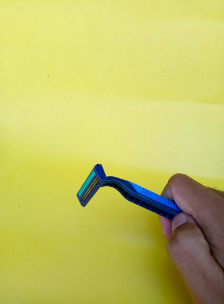 剃须刀。小胡子和剃须刀孤立在一个黄色的背景。塑料剃须刀图片下载