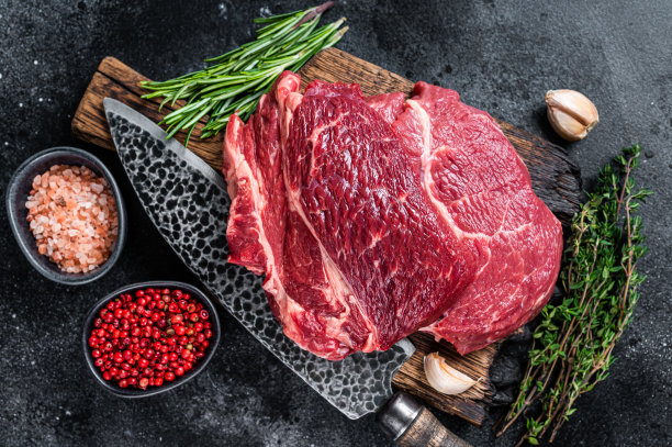 黑安格斯上等牛排，用刀放在肉板上。黑色背景。俯视图图片下载