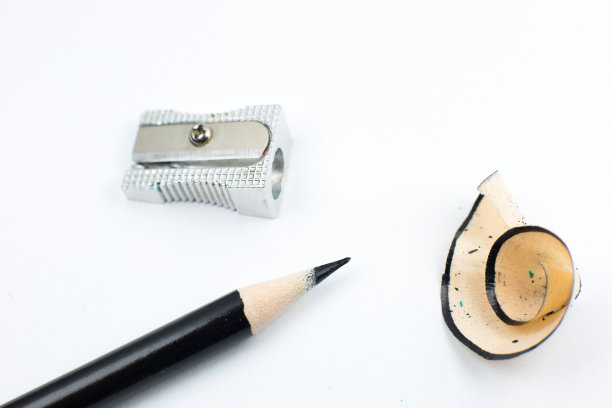 卷笔刀和断了的铅笔。白色背景上的刨花和石墨。特写，微距照片。回到学校的概念。图片下载