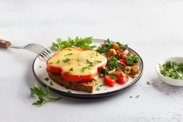 美味的早餐。红甜椒煎蛋配芝士，撒上欧芹碎、番茄、红洋葱和绿色沙拉，底色浅灰色图片下载