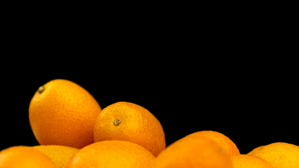 金橘，黑色背景上的新鲜柑橘类水果。金桔，健康食品，生食概念。复制空间照片图片下载