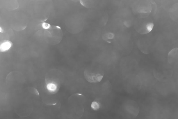 模糊的黑色闪光纹理背景照片。模糊黑色发光散景效果图片下载