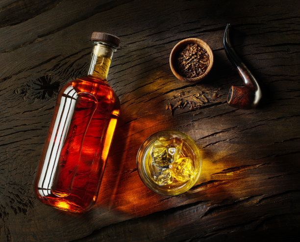 在木板上放一瓶威士忌和一杯威士忌。前视图。图片下载