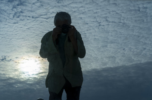 蓝天白云衬托下的男人剪影。图片下载