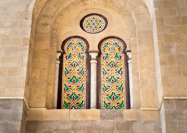 开罗Qalawun建筑群中，两个外部相邻的穿孔灰泥拱形窗户，带有彩色染色玻璃图案图片下载