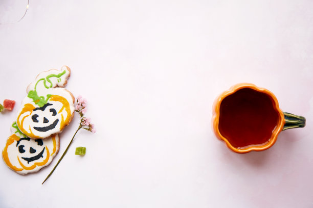 万圣节的静物画有南瓜杯和茶和自制的甜南瓜形状的饼干。明亮的粉红色美学秋季假日或恶作剧或招待的概念。副本的空间。家庭烹饪和舒适图片下载