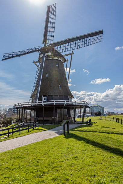 八角形塔式磨粉机，屋顶用茅草顶用来磨粒，坐落在绿草如茵、蓝天白云的小山上图片下载