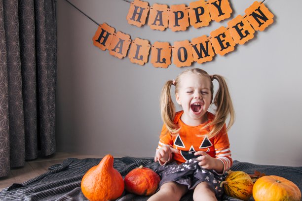 一个穿着南瓜服装的小女孩在万圣节，不给糖就捣蛋。孩子们庆祝万圣节，女孩准备好了恶作剧或招待节日图片下载
