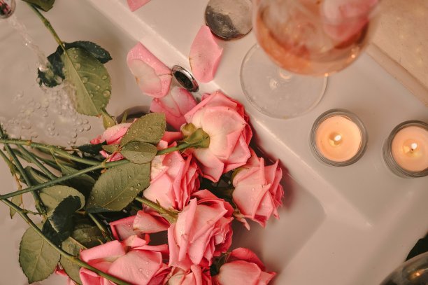 一杯葡萄酒和一束粉红色的玫瑰放在水槽里图片下载