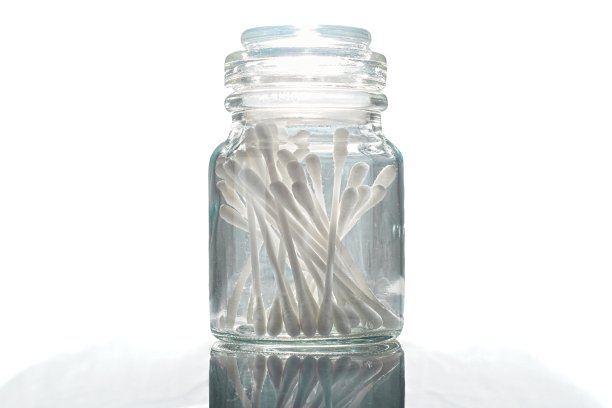 玻璃药瓶装满棉签反射表面图像。图片下载