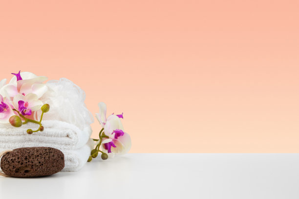 美丽的粉红色花朵和白色毛巾在粉红色的背景图片下载