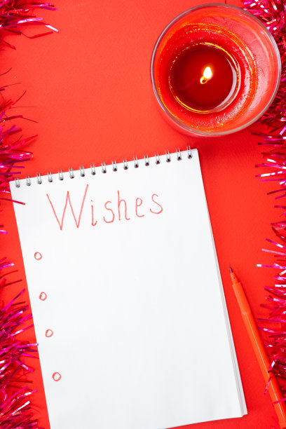 在红色的背景上用燃烧的蜡烛为圣诞老人写祝福。图片下载