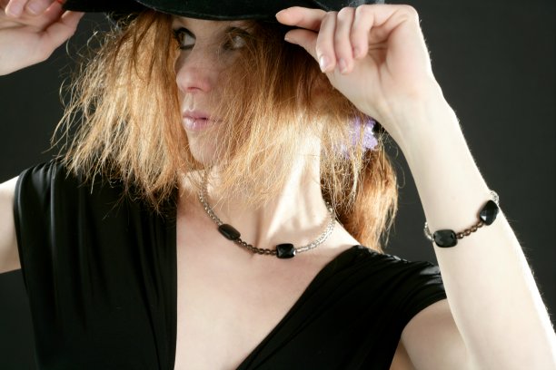 穿黑衣服的红发美女，戴着帽子，戴着珠宝图片下载